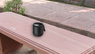 compact bluetooth speaker sitting on a bench